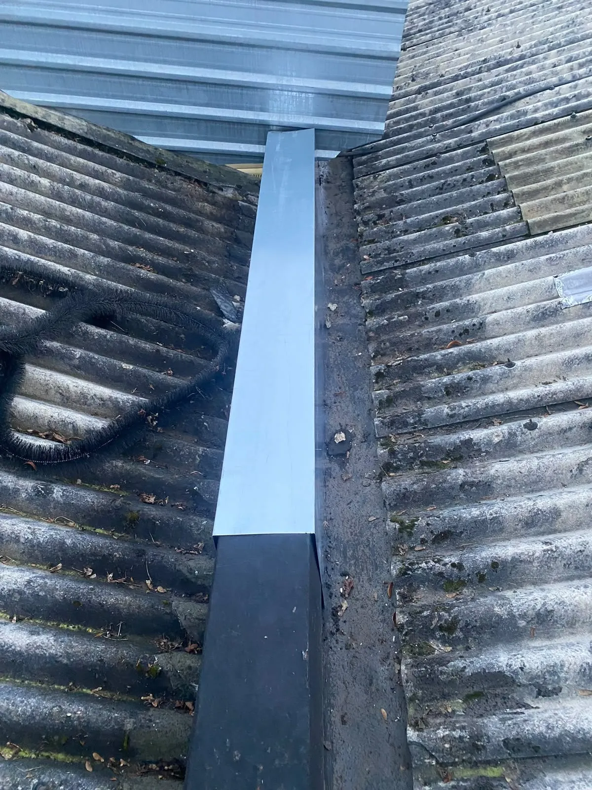 Metal box gutter fitted between two roof slopes