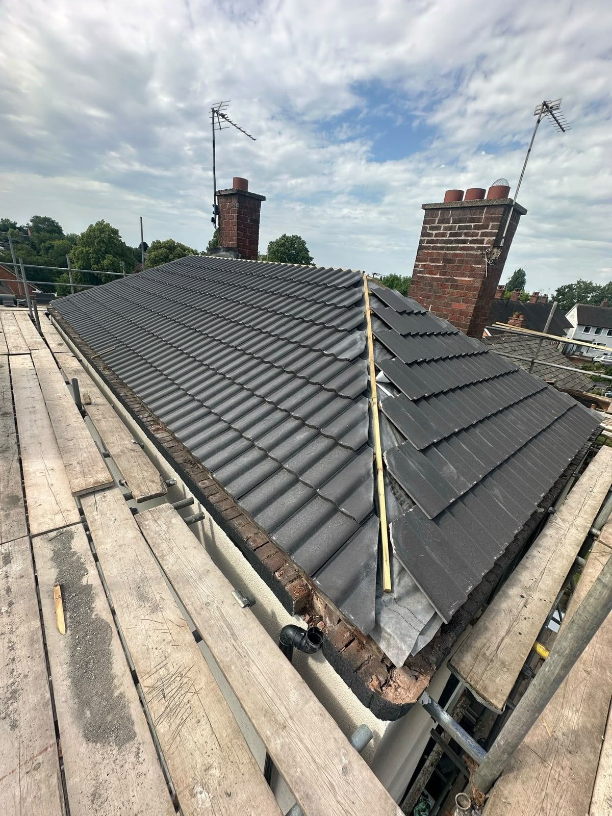 Newly tiled pitched roof with a brick chimney on a house in Birmingham