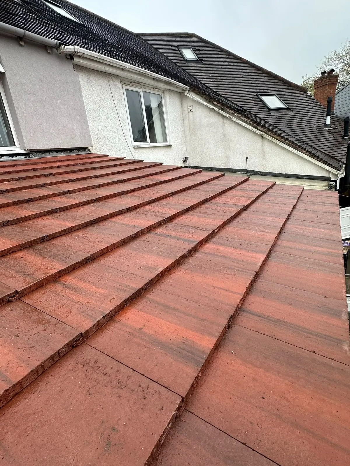 New red concrete roof tiles laid in straight courses on a Birmingham house